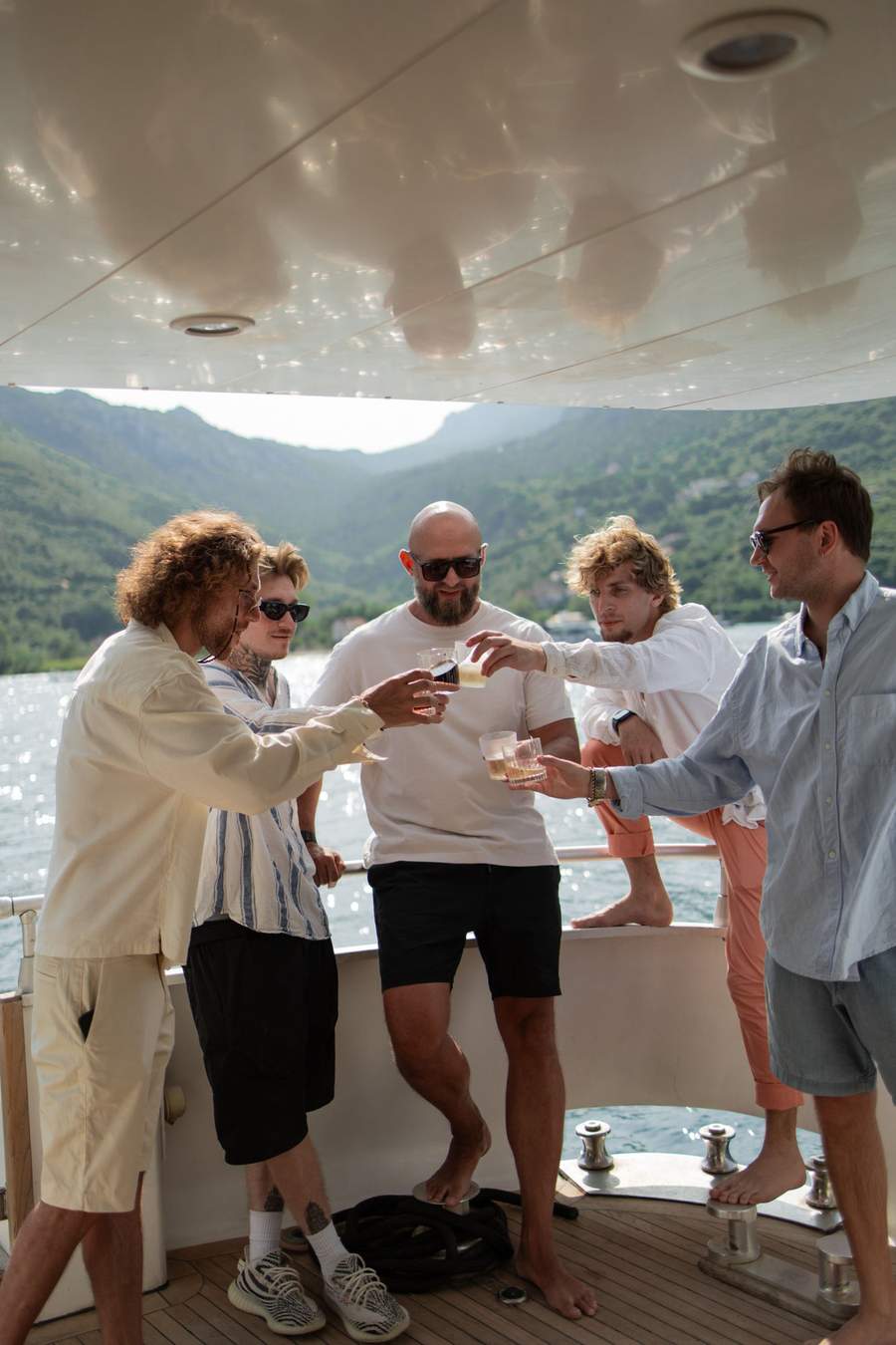 Friends toasting drinks aboard our yacht in Kotor Bay
